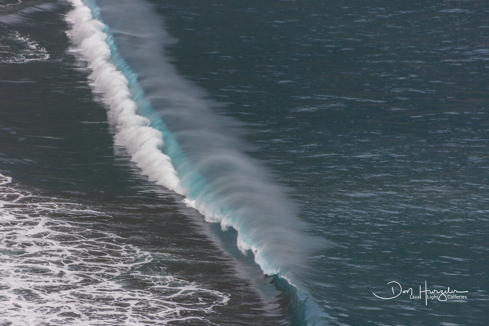 A long wall of water breaking on the beach at Waipo.
